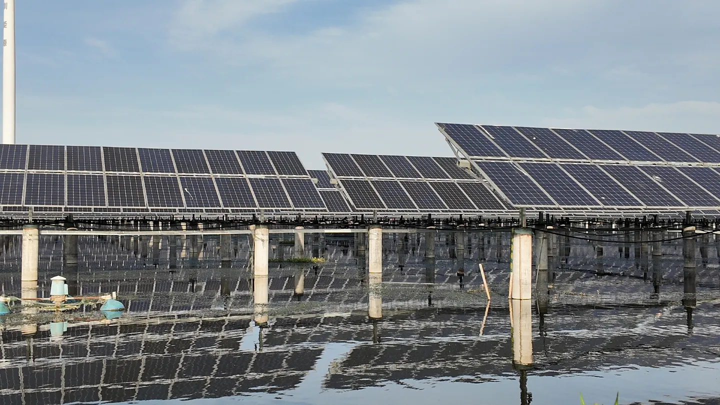 Close-up of solar tracker rows installed over water